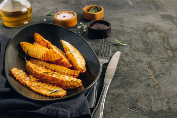 Homemade organic French fries with pink salt and cranberry sauce on black background.