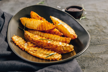 Homemade organic French fries with pink salt and cranberry sauce on black background.