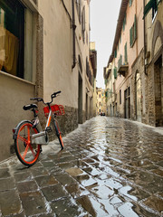 Bicicleta estacionada en una calle lluviosa de Florencia, Italia