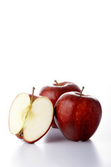 Fototapeta na wymiar Two whole and one half red apples