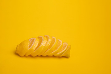 Naklejka premium A lemon cut into slices lies on a yellow background