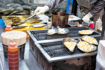 Flame of scallops ~ A kind of street snack Korean food style at Myeong-dong street food, Seoul, South Korea