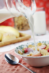 Pouring a jug of milk into breakfast cereal