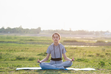 Fototapeta premium Young girl practicing yoga in the nature.female happiness.