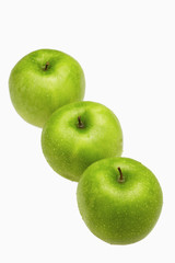 Green apples in a row with water droplets