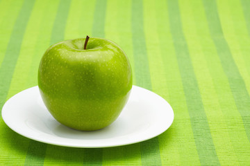Green apple on a plate