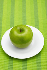 Green apple on a plate