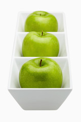Green apples placed in a ceramic dish