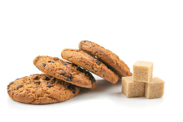 cookies with chocolate chips and three pieces of cane sugar on a white isolated background, macro