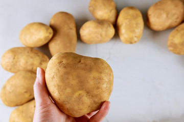 Heart shaped potato in womans hand.