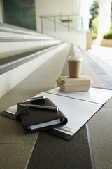 Takeout food, organizer, smart phone and documents left outdoors on stairs