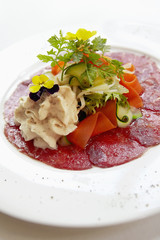 Slices of beef Carpaccio and fresh vegetables with mustard espuma