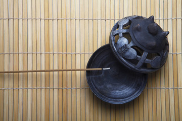 Tip of burning joss stick laying on an ashtray