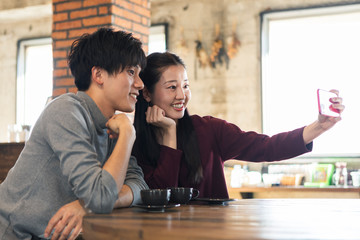 カフェで写真を撮る男女