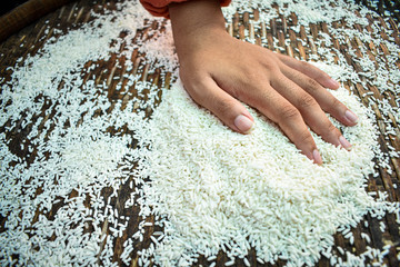 Close up A Farmer Thai woman is using her hands to dry the rice outdoors. Health products