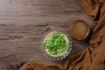 Lod Chong or Cendol dessert,sweetmeat similar in shape to noodles made from rice and Pandan eaten with sweetened coconut milk and palm sugar syrup. on wooden background with copy space.top view. 