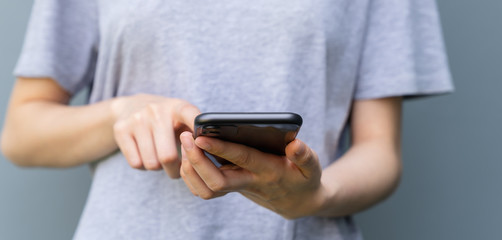 Closeup of young woman hand holding smartphone and chatting with friends at social network.
