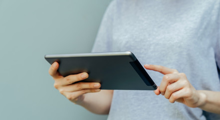 Closeup of young woman hand holding digital tablet.
