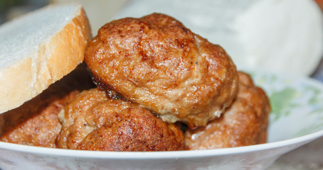 plate on the table with cutlets and a piece of bread  