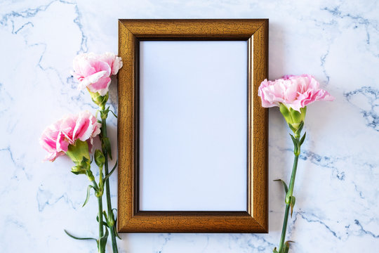 Carnation flower on blank picture frame on marble background, Valentine's Day, Mother's Day or Birthday background