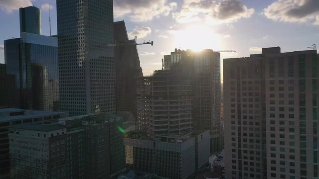 Aerial approach of downtown Houston's high rises with the sunset setting revealed