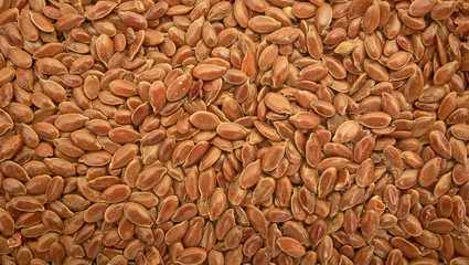 Flax seed is used to make linseed oil. Brown flax seed background.