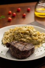 Fototapeta na wymiar Plate with steak tenderloin with fettuccine pasta and and cheese