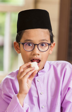 Muslim Boy Eating Ketupat