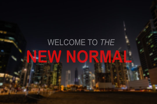 THE NEW NORMAL text on a blurred out Dubai skylines. New normal after covid-19 pandemic. Corona Virus outbreak concept