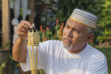 Senior man setting up bamboo torch lamp