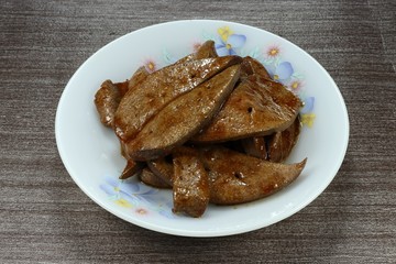 Traditional roasted sliced pork liver with teriyaki sauce on the plate. Famous pork offal menu in Asia. 