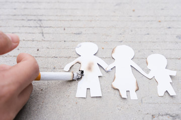 Paper cut of family members destroyed by cigarette. Smoking destroying family concept. Quit smoking...