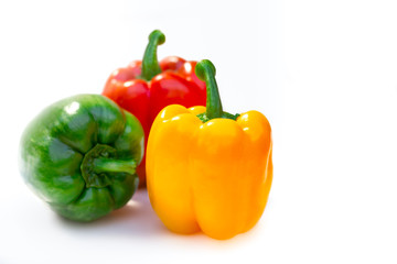 three colors bell peppers or capsicum ; red, yellow and green on white background