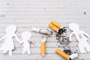 Paper cut of family members destroyed by cigarette. Smoking destroying family concept. Quit smoking for life on world tobacco day.