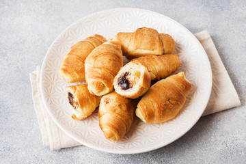 Croissants with chocolate filling on a plate gray background. Copy space.