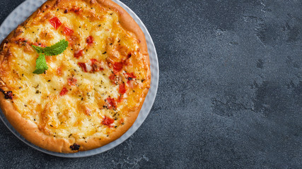 Homemade pizza tortilla with tomato and cheese on gray concrete background. Copy space