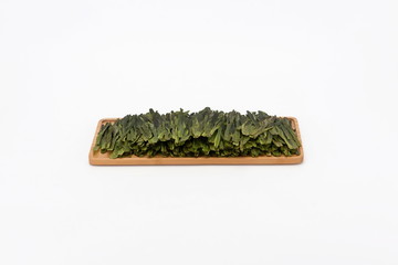 Roasted green tea leaves are placed on wooden trays
