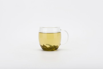 The tea is isolated in a transparent glass against a white background