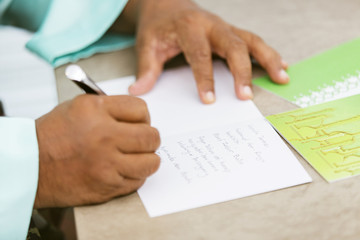 Muslim man writing greeting cards for Eid al-Fitr