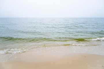 Soft wave with blue ocean on sandy beach.