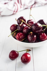 Ripe juicy cherry berries on a plate. White background. Copy space.