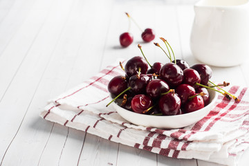 Ripe juicy cherry berries on a plate. White background. Copy space.