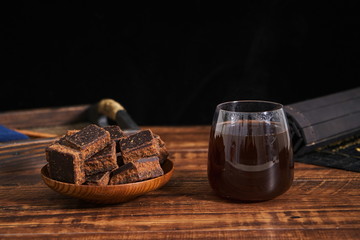 A glass of brown sugar water is on the retro table top