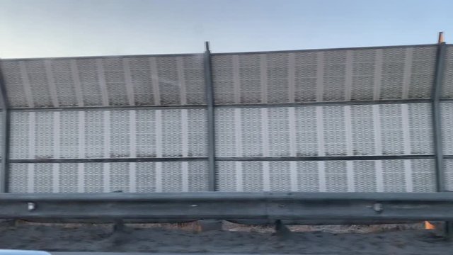Driving on Pulkovo highway, metal noise barrier panel wall, sound barrier fence, Saint Petersburg, Russia.