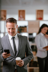 Businessman in office. Handsome man using the phone at work.	
