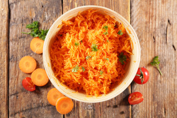 fresh grated carrot on wood background
