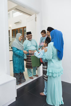 Muslim family visiting senior couple on Eid al-Fitr