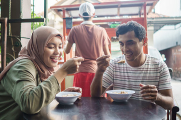 Fototapeta na wymiar bakso. indonesian famous meatball street food. asian woman and man enjoy eating bakso