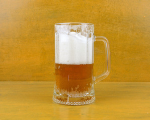 mug of fresh light beer stands on a yellow background