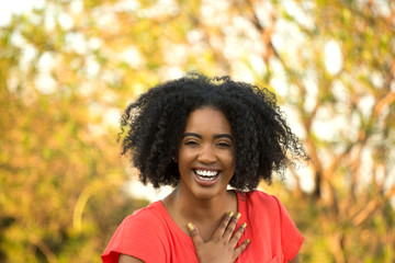 Happy confident African American woman smiling outside.